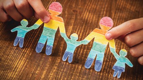 Familie queer: Kind hält Papierschnitt in Regenbogenfarben; © dpa/PantherMedia