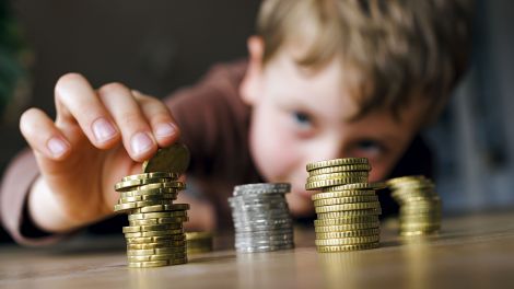 Ein fuenfjaehriger Junge stapelt Kleingeld auf einem Tisch © picture alliance/ photothek/ Thomas Trutschel