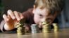 Ein fuenfjaehriger Junge stapelt Kleingeld auf einem Tisch © picture alliance/ photothek/ Thomas Trutschel