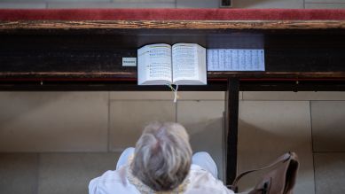 Eine Teilnehmerin hört in einer evangelischen Kirche während eines Sonntagsgottesdiensts der Predigt der Pfarrerin zu, 12.09.2021; © picture alliance/dpa/Silas Stein