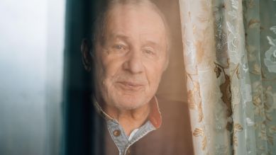 Einsamkeit, Mann steht am Fenster © picture alliance / Shotshop | Addictive Stock