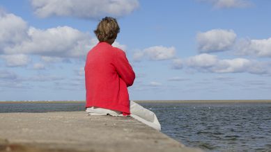 Eine ältere Frau blickt auf das Meer. © picture alliance / Ute Grabowsky/photothek.de | Ute Grabowsky